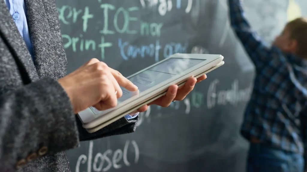 AI Tools for Teachers being used in a modern classroom as an educator uses a tablet with AI-powered learning technology